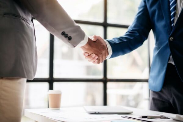 Two men shake hands