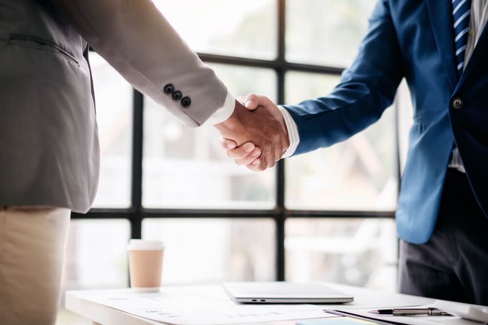 Two men shake hands